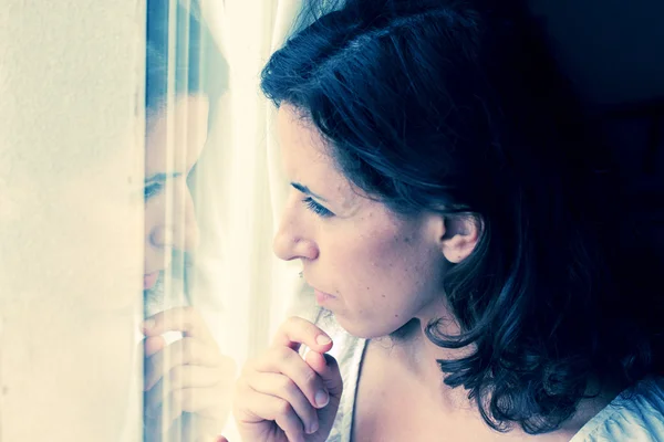 Vrouw in de buurt van venster — Stockfoto
