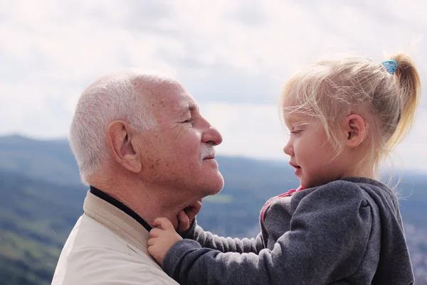 Abuelo sosteniendo a su nieta — Foto de Stock