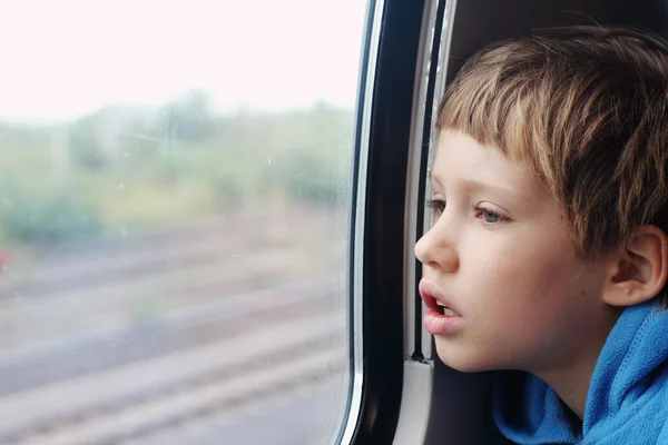 Boy looking through the window — Stock Photo, Image