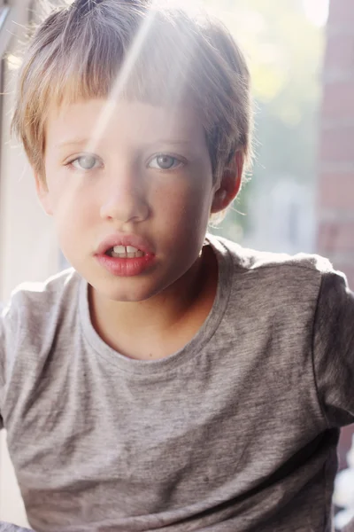 Niño sentado cerca de la ventana — Foto de Stock