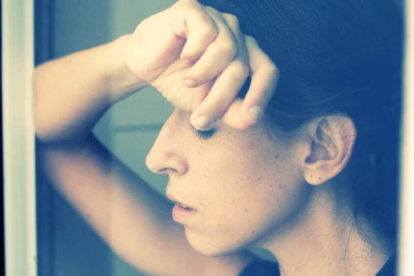 Frau in Fensternähe — Stockfoto