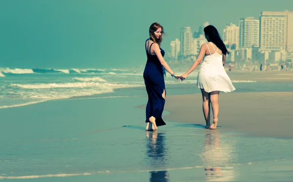 Vriendinnen wandelen op het strand — Stockfoto