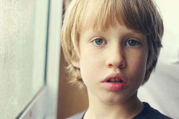 Schattige jongen in de buurt van venster — Stockfoto