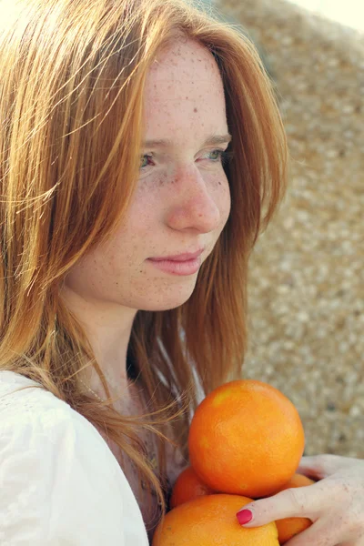 Menina ruiva nova com laranjas — Fotografia de Stock