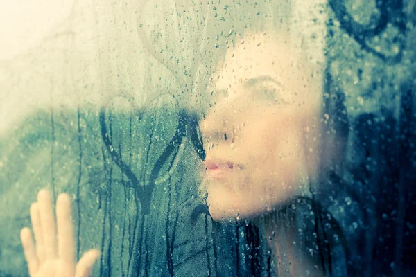 Woman stands in front of window — Stock Photo, Image