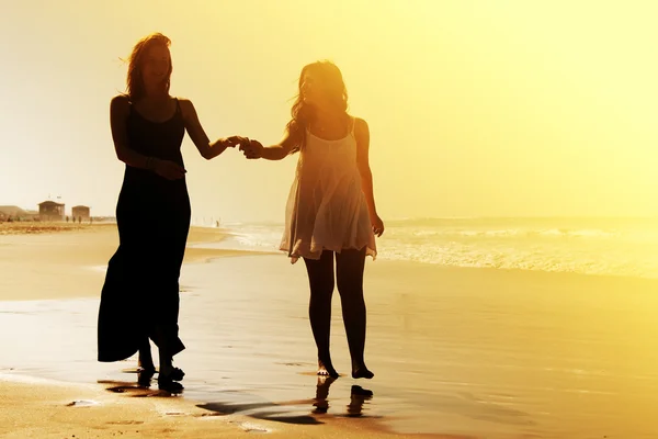 Flickvänner promenader på stranden — Stockfoto