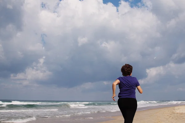 Kobieta biegająca po plaży — Zdjęcie stockowe