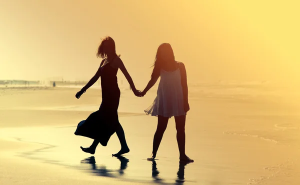 Freundinnen spazieren am Strand — Stockfoto