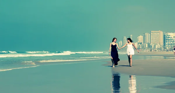 Freundinnen zu Fuß am Strand — Stockfoto