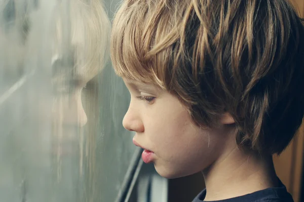 Boy looking through window — Stock Photo, Image