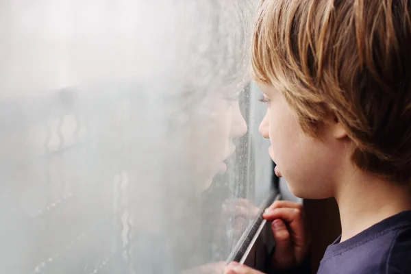 Chico mirando por la ventana — Foto de Stock