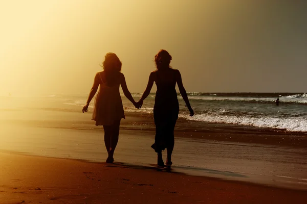 Freundinnen spazieren am Strand — Stockfoto