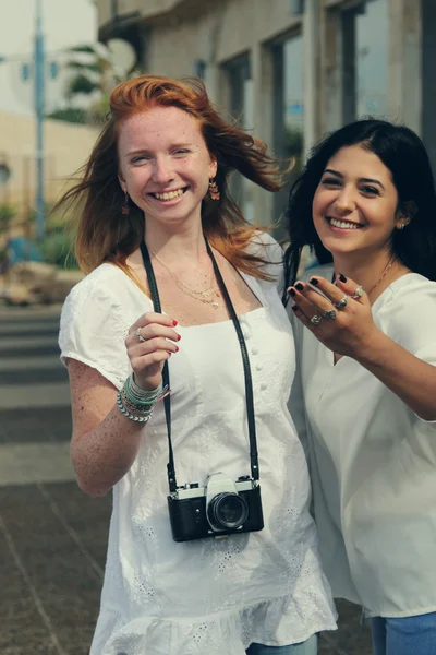 Smiling girlfriends walking in city — Stock Photo, Image