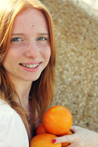 Jeune fille rousse avec des oranges — Photo