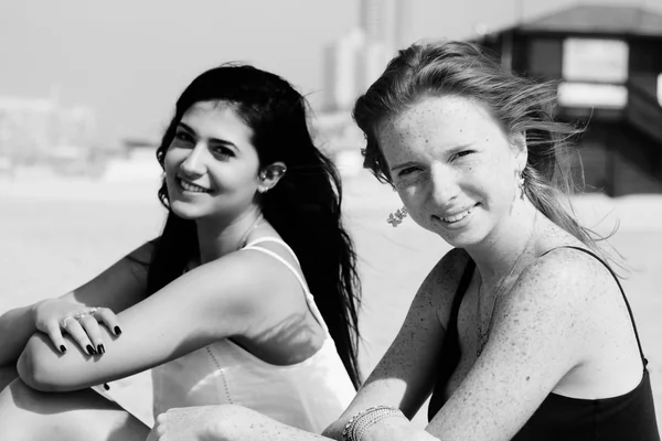 Girlfriends sitting at the beach — Stock Photo, Image