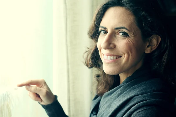 Woman stands in front of window — Stock Photo, Image