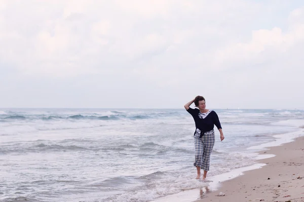 Vrouw die op het strand loopt — Stockfoto