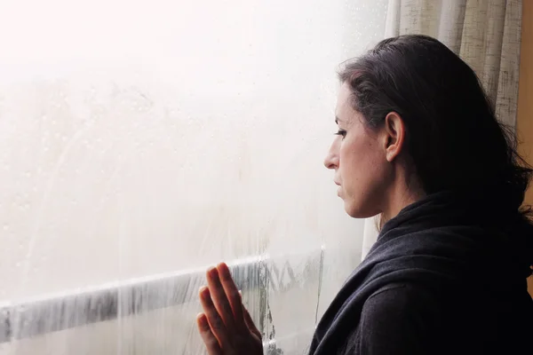 Frau steht vor dem Fenster — Stockfoto