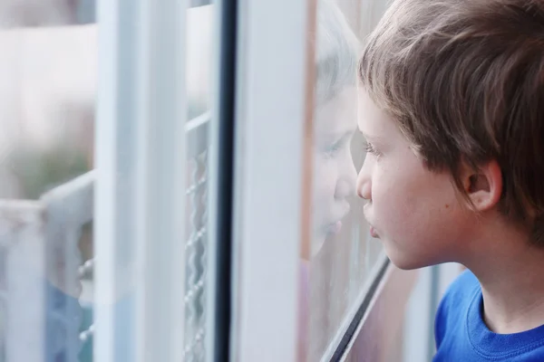 Ragazzo che guarda attraverso la finestra — Foto Stock