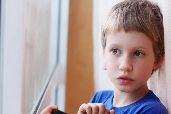 Boy looking through the window — Stock Photo, Image