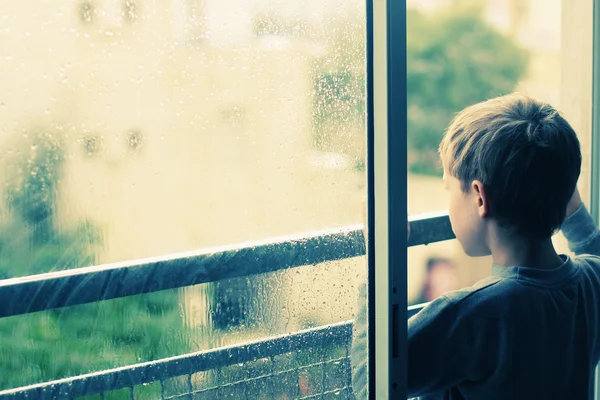 Chico mirando la lluvia — Foto de Stock