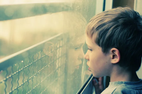 Ragazzo che guarda attraverso la finestra — Foto Stock