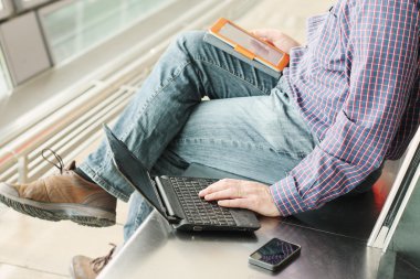 Cep telefonu ve dizüstü bilgisayarı olan adam
