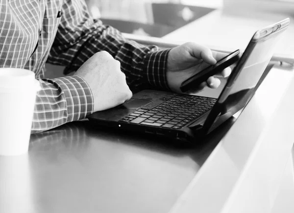 Homem com celular e laptop — Fotografia de Stock