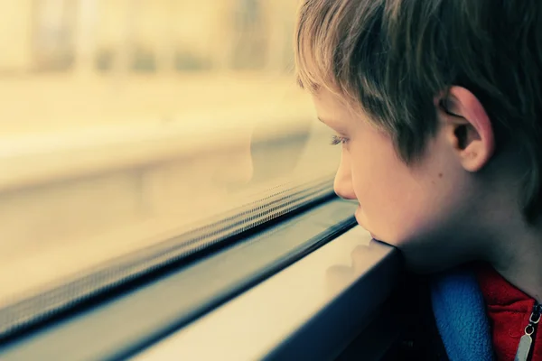 Ragazzo guardando attraverso la finestra — Foto Stock