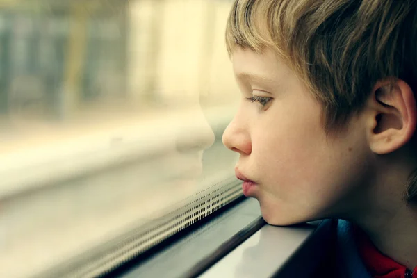 Ragazzo guardando attraverso la finestra — Foto Stock