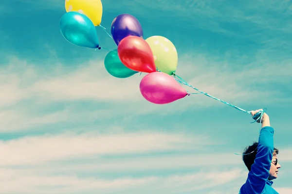 Vrouw bedrijf kleurrijke ballonnen buiten — Stockfoto