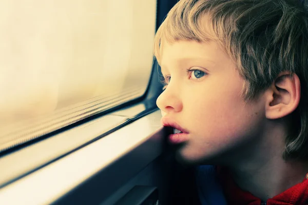 Chico mirando por la ventana — Foto de Stock