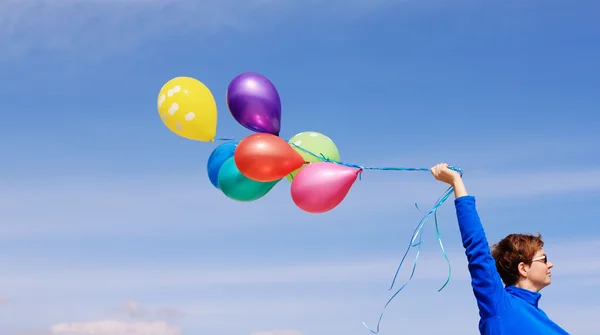 Kvinna som håller färgglada ballonger — Stockfoto