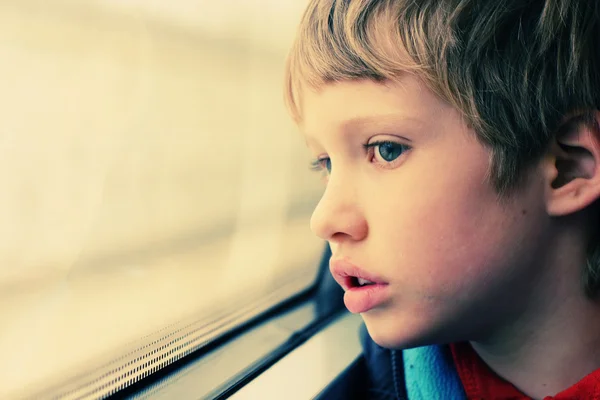 Ragazzo guardando attraverso la finestra — Foto Stock