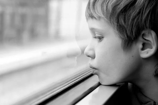 Ragazzo guardando attraverso la finestra — Foto Stock