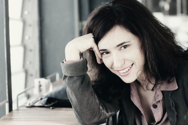 Kafede oturan gülümseyen kadın