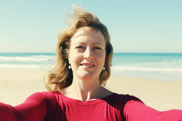 Mujer madura haciendo selfie en la playa — Foto de Stock