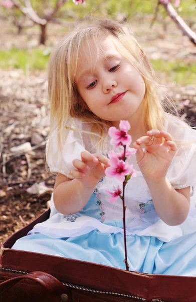 Leuk meisje spelen met bloemen — Stockfoto