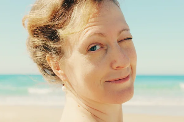 Mooi meisje glimlachend op het strand — Stockfoto