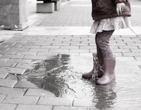 Beine eines kleinen Mädchens in Regenstiefeln — Stockfoto