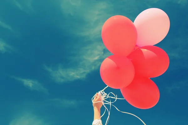 Hand innehav röda ballonger — Stockfoto