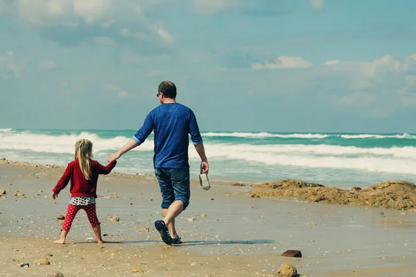 Vader en dochter wandelen op het strand — Stockfoto