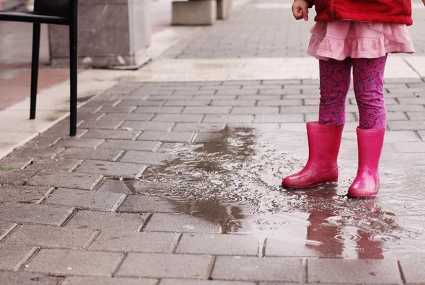 Beine eines kleinen Mädchens in Regenstiefeln — Stockfoto