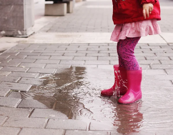 Piernas de niña en botas de lluvia — Foto de Stock