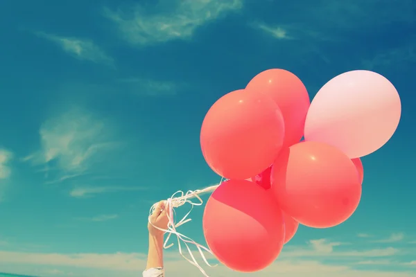 Hand innehav röda ballonger — Stockfoto