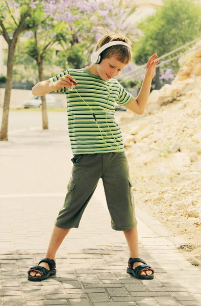 Jongen met koptelefoon dansen op de straat — Stockfoto