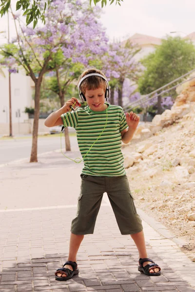 Niño con auriculares bailando en la calle — Foto de Stock