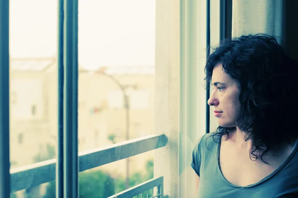 Женщина стоит перед окном — стоковое фото