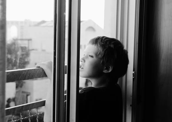 Chico mirando por la ventana — Foto de Stock