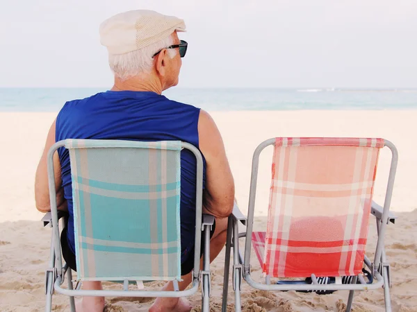 Uomo seduto sulla spiaggia — Foto Stock